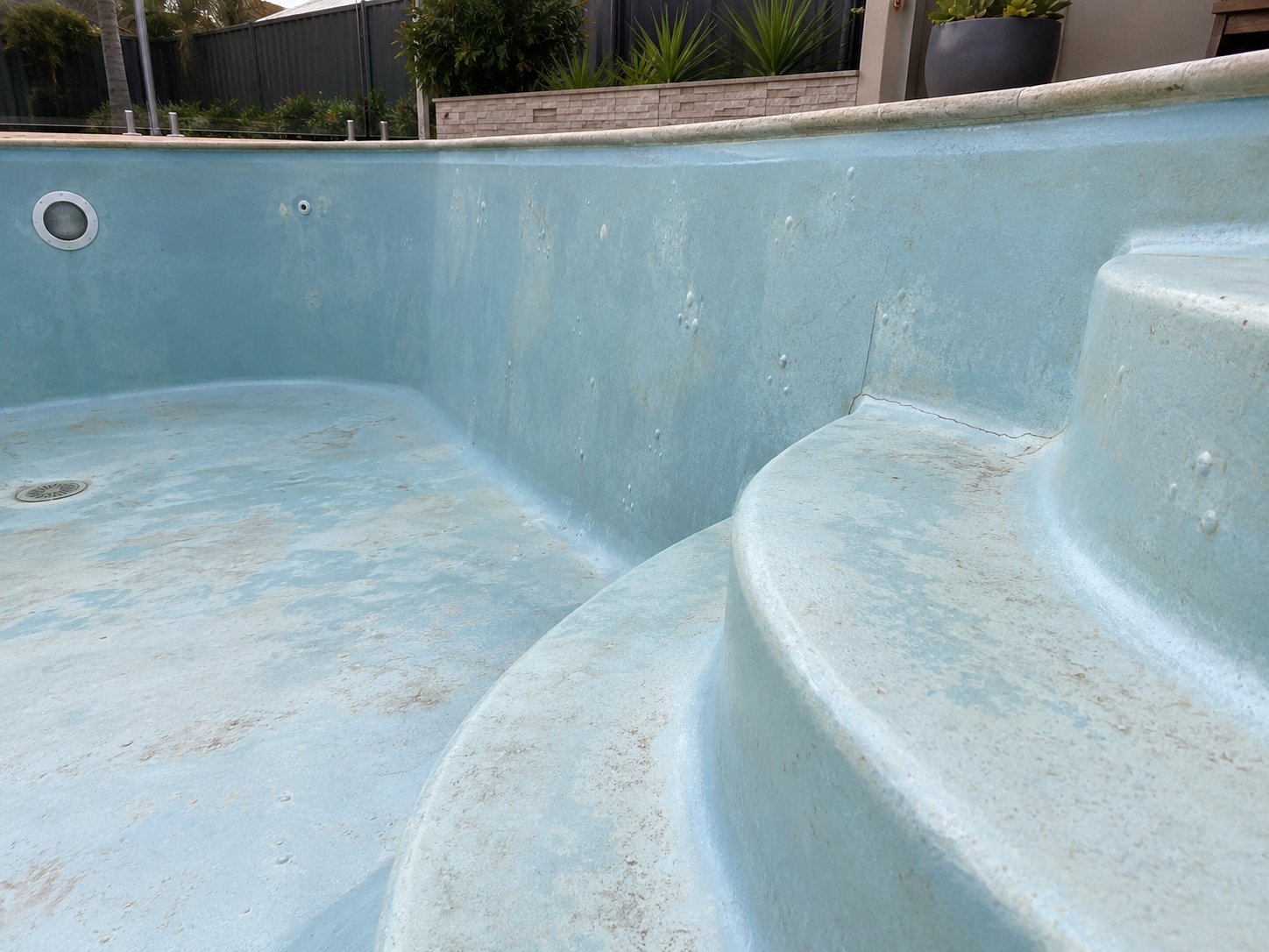 Representative fibreglass pool surface showing blisters and a crack